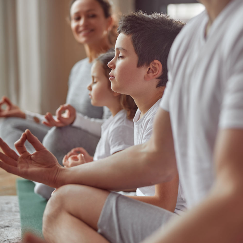 Kinder meditieren gemeinsam mit ihren Eltern
