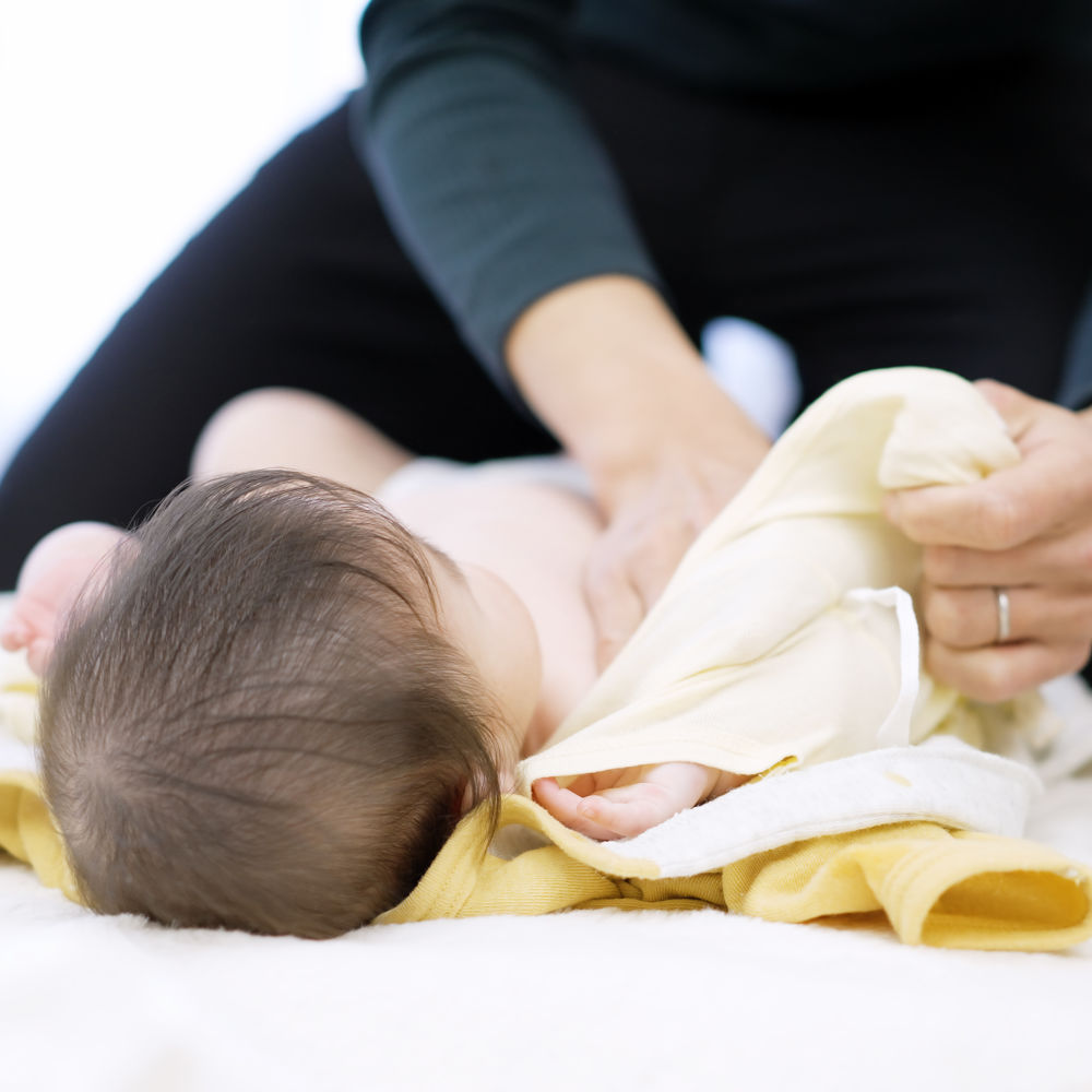 Ein Baby bekommt eine Massage beim Baby-Yoga