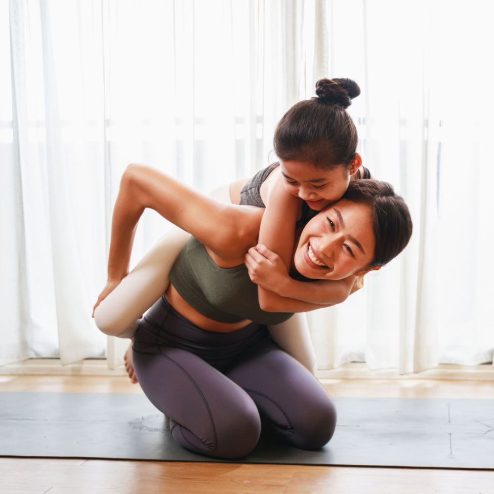 Ein Mädchen und ihre Mutter haben Spaß bei einer gemeinsamen Yogaübung