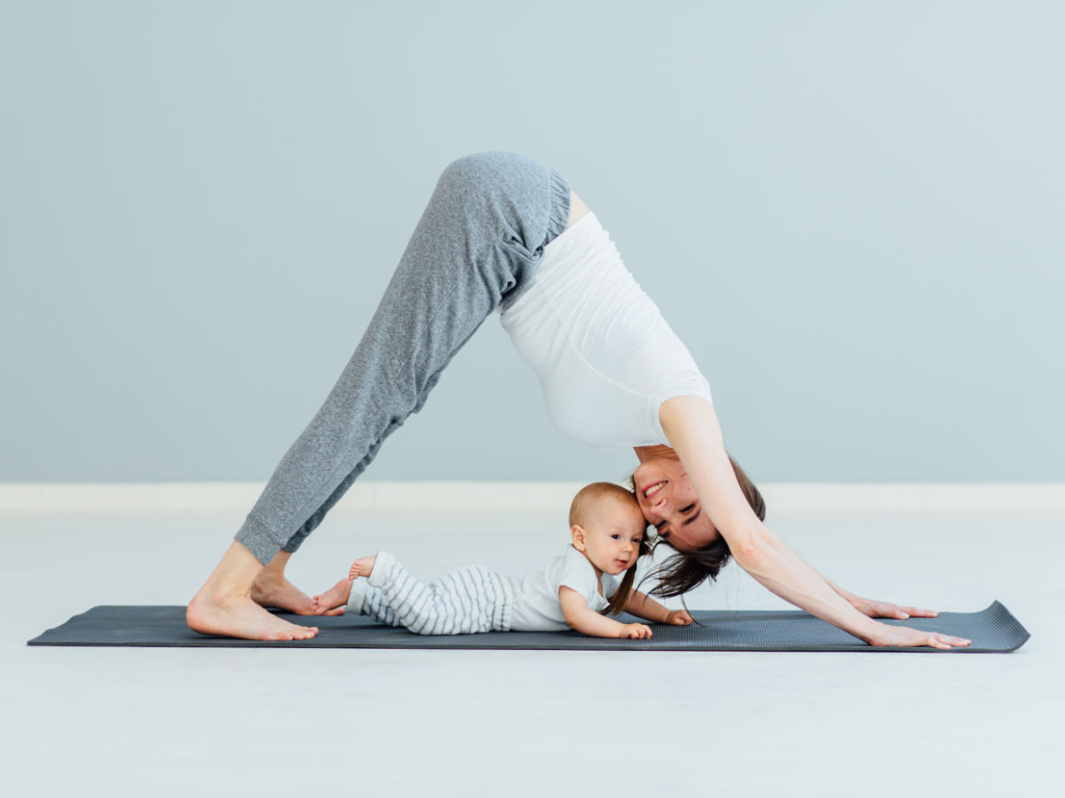 Eine Mutter führt eine Yoga-Übung mit ihren Kind durch